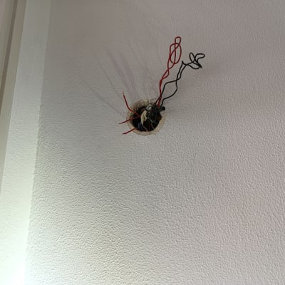 חוטי חשמל אדומים ושחורים יוצאים מהקיר