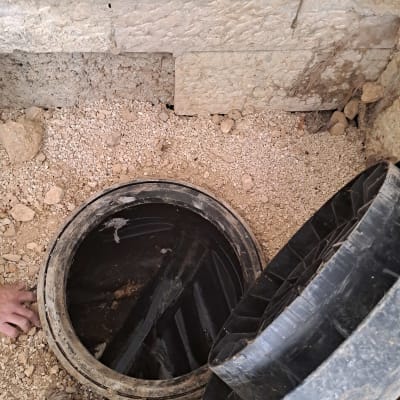 פתח ביוב פתוח עם מכסה מונח בצד