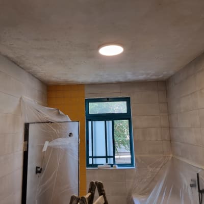 חדר אמבטיה עם תקרה צבועה ואריחים מכוסים בניילון