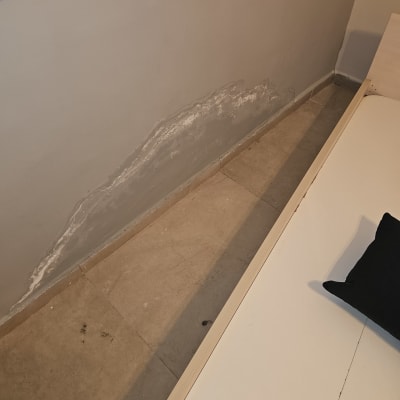 כתם רטיבות על קיר ליד הרצפה