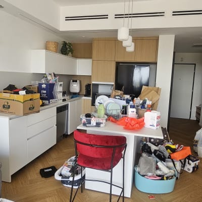 מטבח עם חפצים רבים על השיש והכיסאות, מתאים לארגון בית.