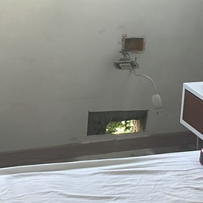 שקע חשמלי פתוח בקיר עם חוטים חשופים