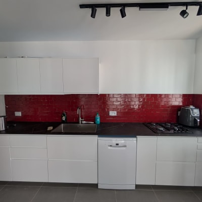 מטבח עם אריחים אדומים, כיור וברז, כיריים