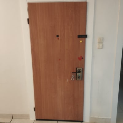 דלת עץ עם מנעול ובריחים על קיר לבן