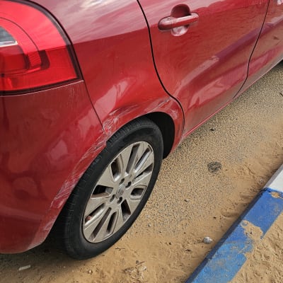 מכונית אדומה עם שריטות על הפגוש האחורי