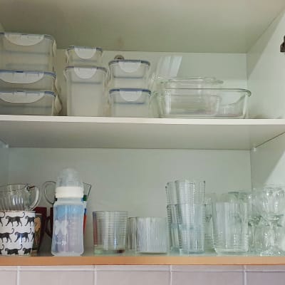 ארון מטבח עם קופסאות פלסטיק, כוסות וזכוכית