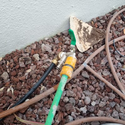 צינור מים עם ברז על רקע אבנים קטנות