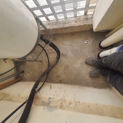 צינורות ומיכל מים על רצפת בטון