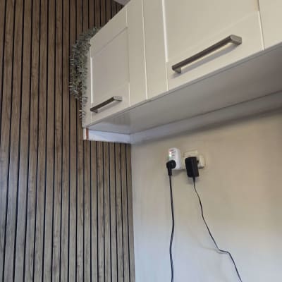 ארונות מטבח לבנים עם קיר עץ ותקע חשמלי