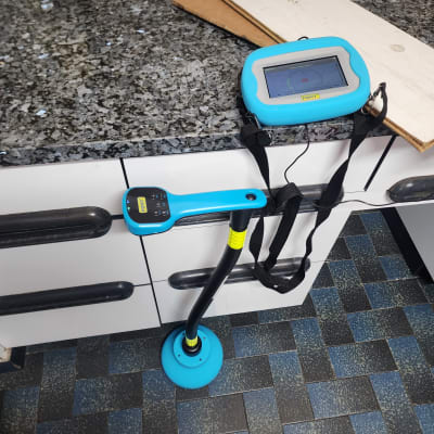 מכשיר איתור נזילות כחול על רצפה וארון מטבח