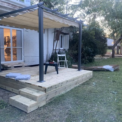 פרגולה מעץ עם כיסוי בד על דק עץ בגינה