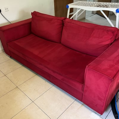 ספה אדומה עם צינורות ניקוי על הרצפה