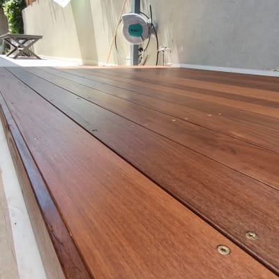 דק עץ חום בגינה עם קיר בטון