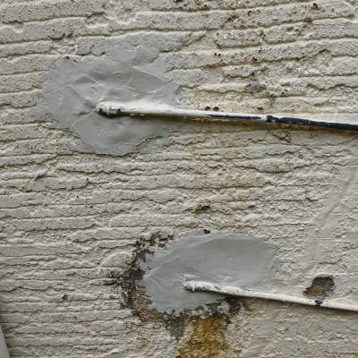 צינורות מתכת עם תיקוני טיח על קיר