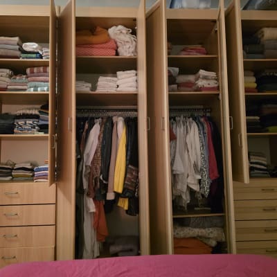 ארון בגדים מסודר עם בגדים מקופלים ותלויים