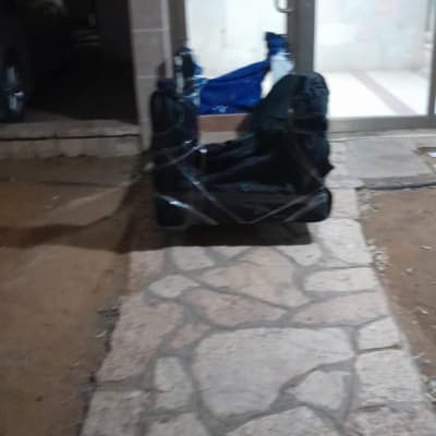 חפצים עטופים בניילון שחור מונחים על שביל אבן