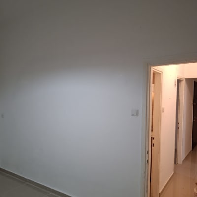 קיר לבן עם דלת פתוחה וחדר פנימי