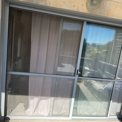 דלת הזזה מזכוכית עם וילון ורקע חיצוני