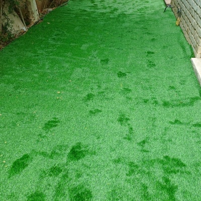 דשא סינתטי ירוק עם עציצים בצדדים