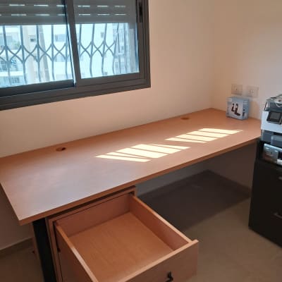 שולחן עץ עם מגירה פתוחה בחדר מואר