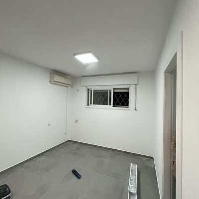 רולר צביעה על רצפה בחדר ריק עם קירות לבנים