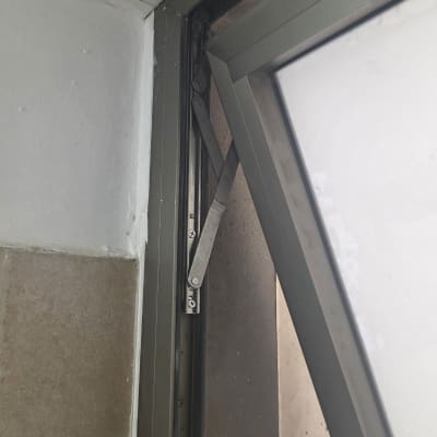 חלון פתוח עם מסגרת מתכת וקיר לבן