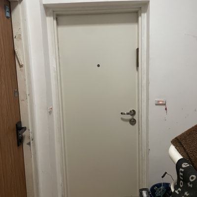 דלת לבנה עם ידית כסופה וקיר לבן