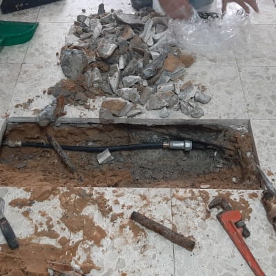 תיקון צינור מים מתחת לרצפה עם כלים שונים