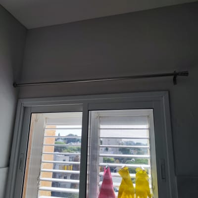 חלון עם תריסים, כפפות גומי ומטלית תלויים