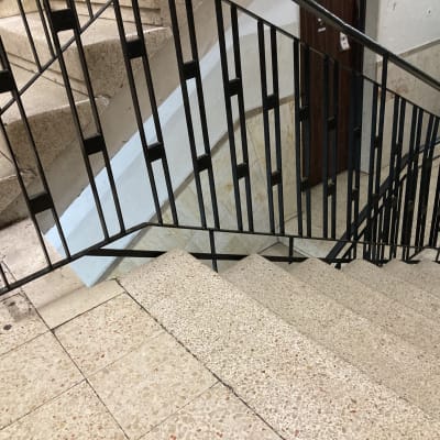 מעקה מתכת שחור על מדרגות אבן