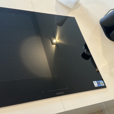 כיריים חשמליות ומכונת קפה על משטח עבודה במטבח