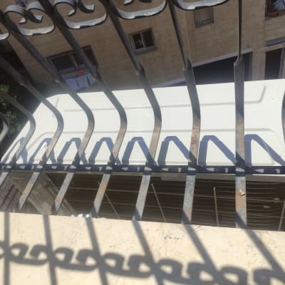 יחידת מזגן חיצונית מאחורי סורגי מתכת