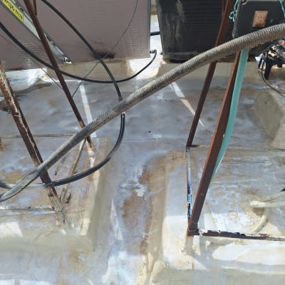 עבודת איטום על גג עם צינורות ומתקנים