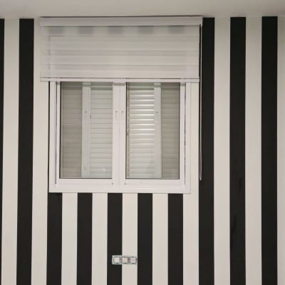 קיר עם טפט פסים בשחור ולבן ושעון גדול