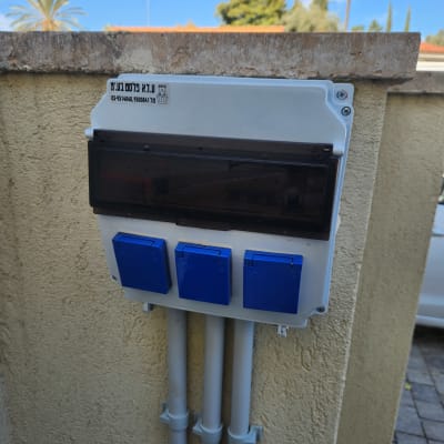 תיבת חשמל עם שלושה שקעים כחולים על קיר