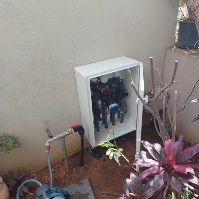 מערכת השקיה אוטומטית עם צינורות וברזים בגינה