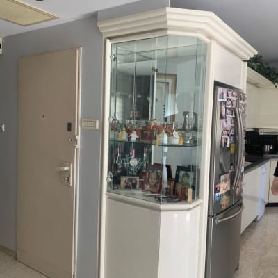 ארון זכוכית עם בקבוקים ותמונות בפנים