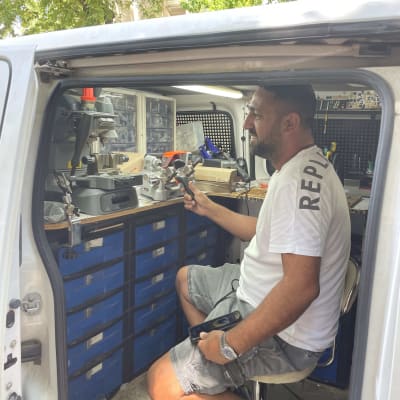 אדם יושב ברכב עבודה עם כלי עבודה למנעולן
