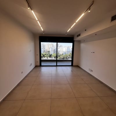 חדר ריק עם רצפת אריחים וחלון גדול