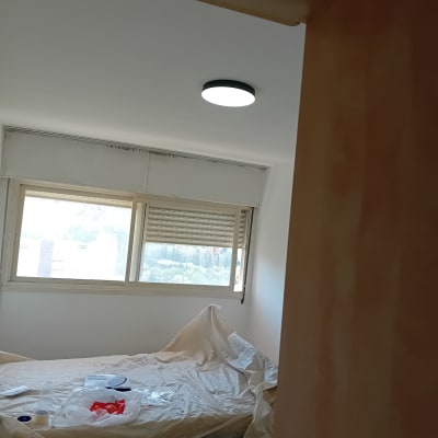 חדר עם קירות צבועים ומיטה מכוסה בניילון