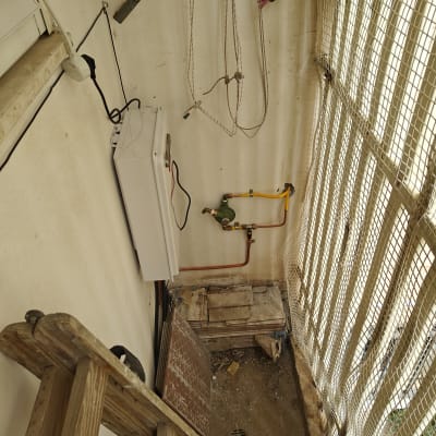 מערכת גז עם צינורות כתומים וקופסה לבנה על קיר