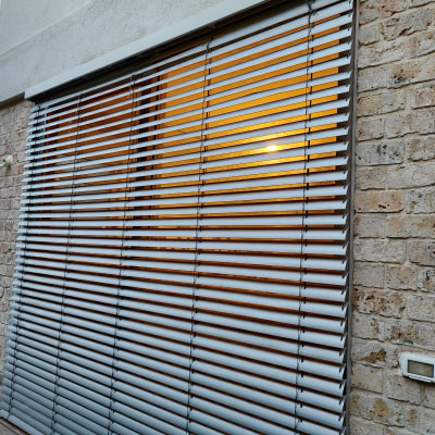 תריסים אופקיים מתכתיים על חלון גדול