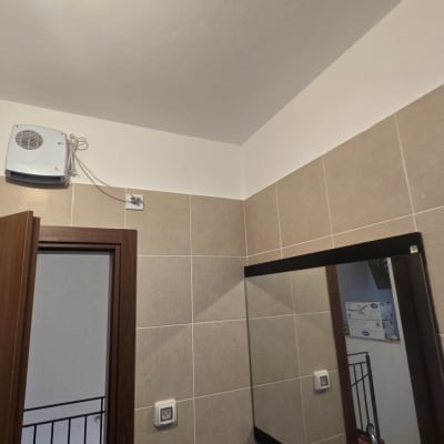 קיר עם אריחים ומראה בחדר אמבטיה