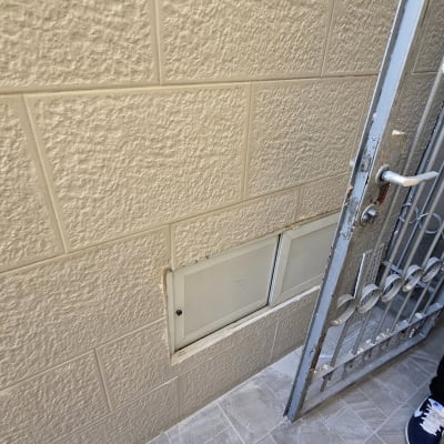 תמונה של קיר עם אריחים ודלת מתכת פתוחה