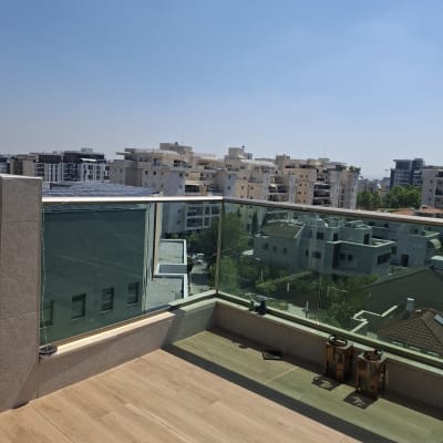 מרפסת עם מעקה זכוכית ונוף עירוני