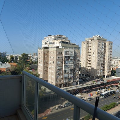 רשת נגד יונים מותקנת על מרפסת בניין