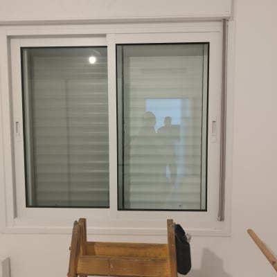 חלון עם תריסים סגורים ומדרגות עץ