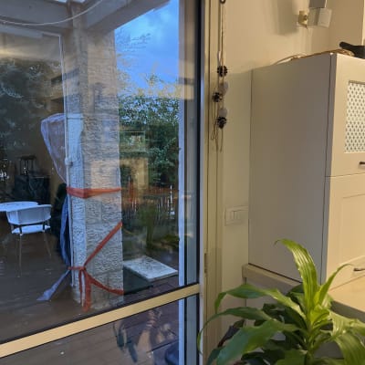 חלון עם תריסים וצמח בפנים הבית