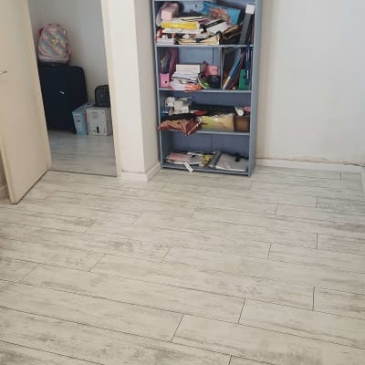 חדר עם מדף עמוס ופרקט עץ בהיר