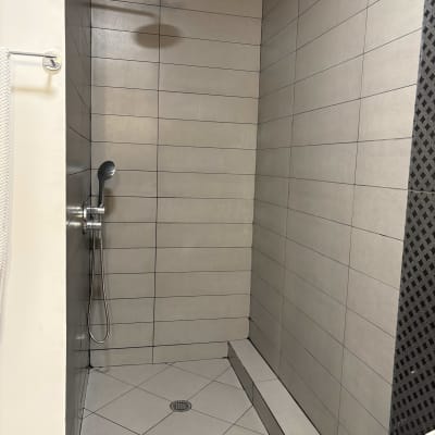 מקלחת עם אריחים אפורים וראש מקלחת